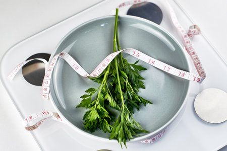 a plate of greens wrapped with a measuring tape, standing on the scales the concept of vegetarianism vegan diet. high quality photoの写真素材