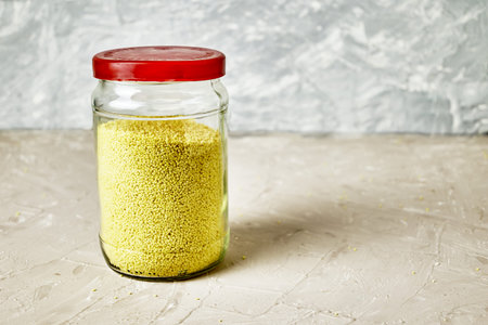 grits couscous in a glass jar on the table copy space. high quality photoの写真素材