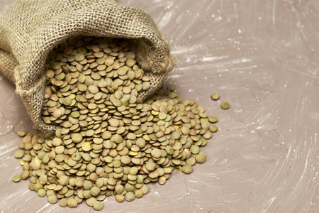 lentil grains poured out of a canvas bag on the table. high quality photoの写真素材