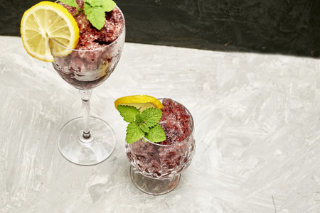 frozen red wine in two glass glasses decorated with a slice of lemon and lemon leaves. high quality photoの写真素材