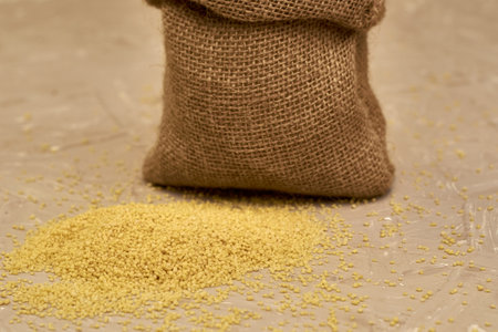 crop couscous poured out of a canvas bag on the table. high quality photoの写真素材