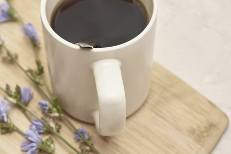 a mug with a drink and chicory flowers on a cutting board