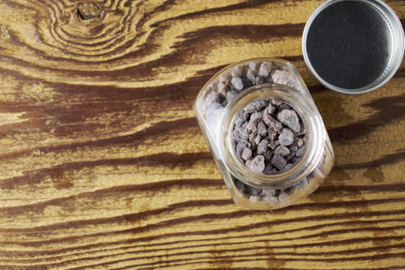 Black salt Kala namak in a glass salt shaker on a wooden table with a copy space. high quality photoの写真素材