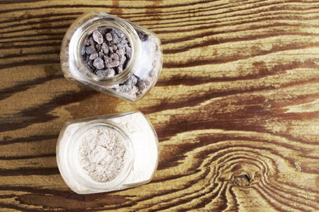 Black salt Kala namak, finely and coarsely ground in glass salt shakers on a wooden table with a copy space. high quality photoの写真素材