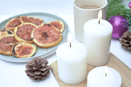 Christmas card burning candles fried oranges cones Christmas tree toys and a mug of coffee on the windowsill on a winter day. high quality photoの写真素材