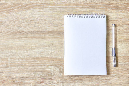 an open notepad for notes and a pen on a wooden table with a copy space top view. high quality photoの写真素材