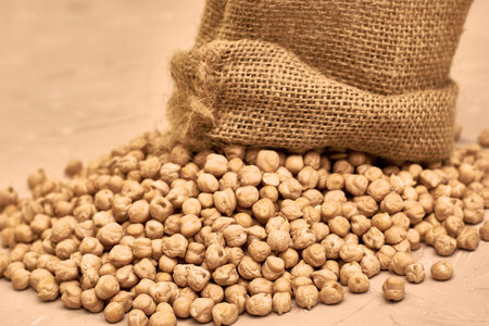 chickpeas in a canvas bag and scattered on the tableの写真素材