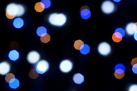 multicolored festive lights on a black background screensaver backdrop. high quality photoの写真素材