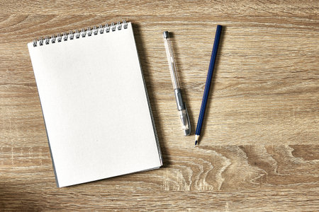 open notepad for notes pencil and pen on a wooden table with a copy space top view. high quality photoの写真素材
