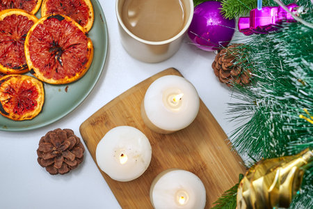 Christmas card burning candles fried oranges cones Christmas tree toys and a mug of coffee on the windowsill on a winter day. high quality photoの写真素材
