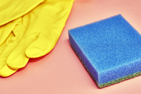 household gloves and sponge on pink backgroundの写真素材