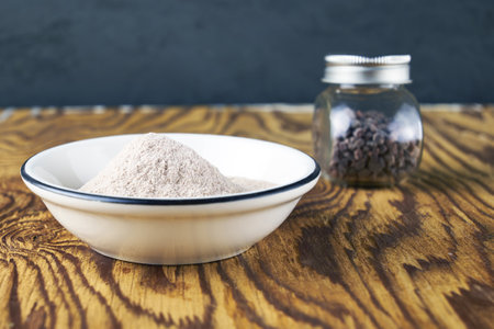 Black salt Kala namak in a glass salt shaker and on a plate on a wooden tableの写真素材