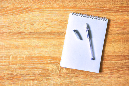 an open notepad for notes and a pen on a wooden table with a copy space top view. high quality photoの写真素材