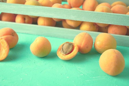 ripe juicy apricots in a wooden box and on the tableの写真素材