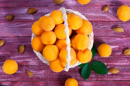 ripe juicy apricots in a basket on a wooden backgroundの写真素材