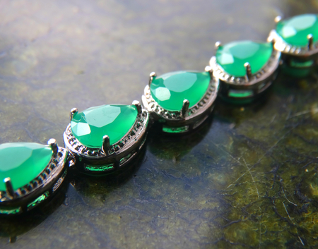 Female bracelet on a dark background decoration bijouterie gift accessory material silver female rock green emerald sapphireの写真素材