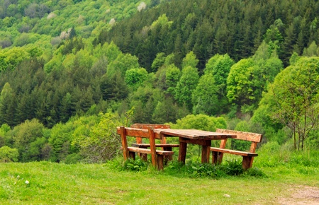 Two benches with a table in the mountainの写真素材