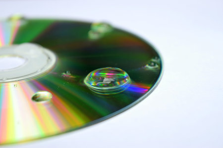 cd with a drop of water on a white backgroundの写真素材
