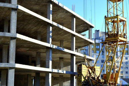 fragment of yellow crane near the under construction objects