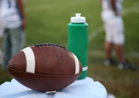 Football Sitting on Cooler beside Sports Drinkの写真素材