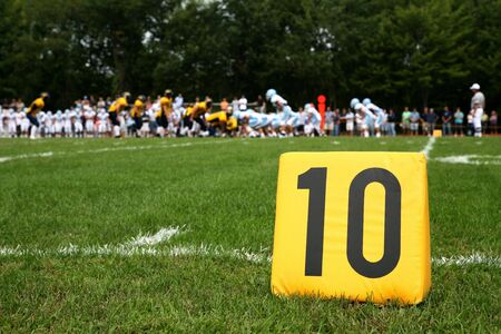 ten yard line marker with football play behindの写真素材