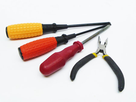 Screwdrivers and pliers on white background