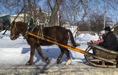 The Shrovetide. Walk of the boys on vehicle with horseのeditorial素材