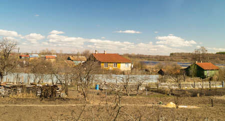 Rural landscape in village by springtime on background blue sky and white cloudの写真素材
