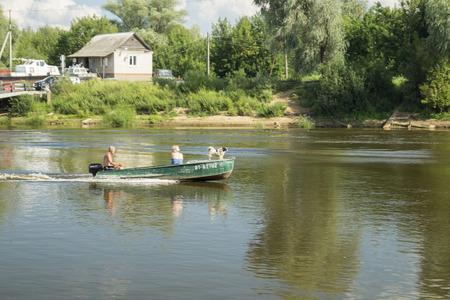 Vyazniki,Russia-August 1,2016: Man and woman with dog sail on boat on river 1 August 2016 in city Vyazniki,Russiaのeditorial素材
