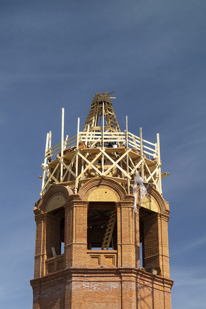 The Construction to bell towers in city Vyazniki,Russia. Building from red brick on background blue skyの写真素材