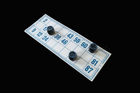 Blanching card lotto with blue number on black background. The Black cask with number in turn blue the circle. Photography type overhandの写真素材
