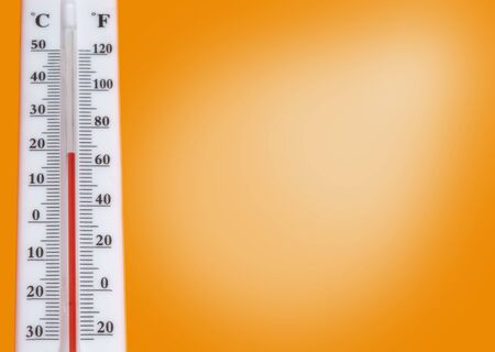 The White thermometer with scale on orange background. Started space for designの写真素材
