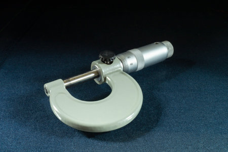 The Instrument micrometer on turn blue the table on black background.Mechanical instrument for measurement from steelsの写真素材