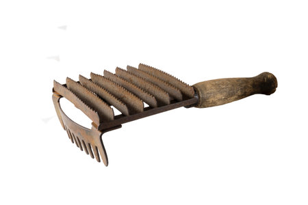 Old metal brush with wooden handle for pet grooming. Rusty object isolated on a white background