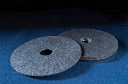 A cutting disc for a grinder on a blue table. Locksmith tools on a black background