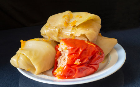 Pepper and stuffed cabbage rolls on a plate. Food on a black backgroundの写真素材