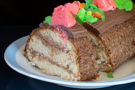 Sweet cake on a plate with a blue stripe. food on a black background
