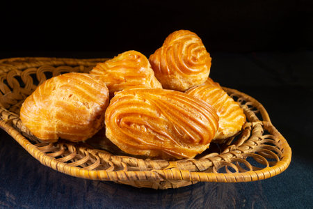 Sweet eclairs in a plate on the table. food on a black background