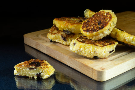 Fried cottage cheese with raisins on a glass table. food on a black background