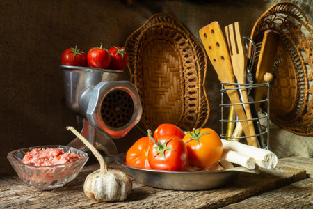 Still life with vegetables and kitchen utensils. Food on a dark background. Preparation of spicy seasoningの写真素材