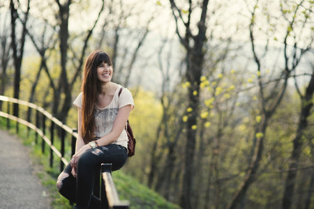 Attractive young woman enjoying her time outside in park . Caucasian girl with long brown hair smiling.の写真素材
