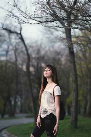 Attractive young woman enjoying her time outside in park . Caucasian girl with long brown hair in a serene  pose and closed eyes.の写真素材