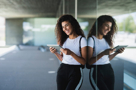 Young black woman with curly long hairstyle Leaning against the wall reflecting herself. Mixed girl...
