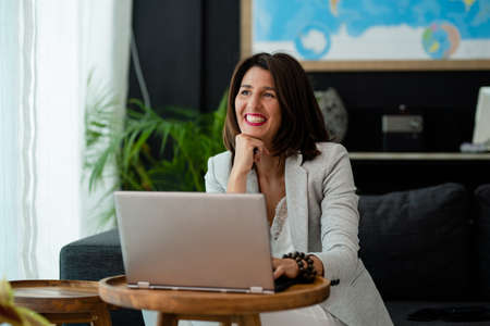 Smiling bussines woman working at home with laptopの写真素材