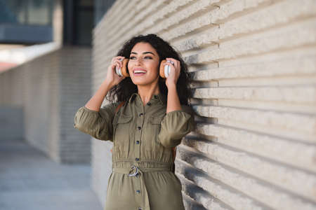Attractive young woman with headphones on th streetの写真素材