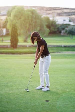 Woman playing golf on beautiful golf courseの写真素材