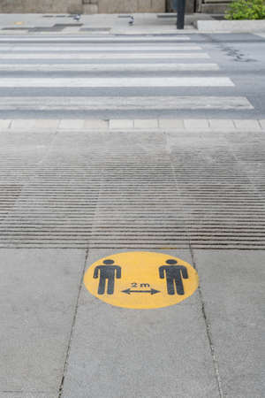 a two meters social distance sign drawn on the ground during the coronavirus pandemicの写真素材
