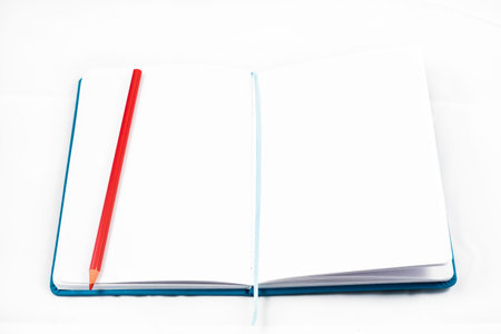top view of an open notebook to take notes with red pencil on white background. design concept