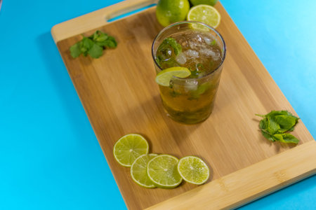 Cuban mojito made with rum, lime, brown sugar and soda on a wooden board. typical Cuban drink. blue backgroundの写真素材