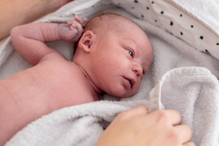 close-up of a baby with a few days of life lying in her crib. concept family and care of the newbornの写真素材